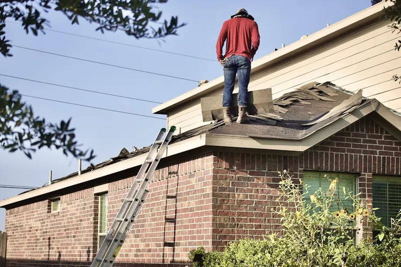 Professional roofer working on a residential roof in Olivette